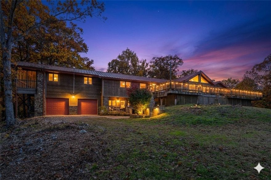 Tucked in nearly 30 rolling acres just outside Rogers, this striking modern home offers breathtaking Ozark Mtn views & a true connection to nature. Designed w/ clean lines & geometric windows reminiscent of F.L. Wright, it blends modern architecture w/ tranquil natural beauty. Main level features gourmet kitchen, cathedral ceilings & 2 lg living areas—ideal for entertaining or everyday living. Lower-level in-law suite w/ private entrance offers flexibility for guests or multi-gen living. Escape light pollution—stargaze by the fire on the large deck or catch panoramic sunset views over a peaceful valley. Fenced, flat front lawn & gardens add charm, while a detached wrkshp & 4-car garage provide practicality & room to create. Multiple bldg sites offer room to expand or customize your dream retreat. Just 12 mi from Hobbs St Park– Conservation Area w/ 50+ mi of trails & Beaver Lake nearby. Monte Ne Boat Ramp & Prairie Creek Marina mins away.Rare blend of design, serenity & adventure in NWA- See attachments for info