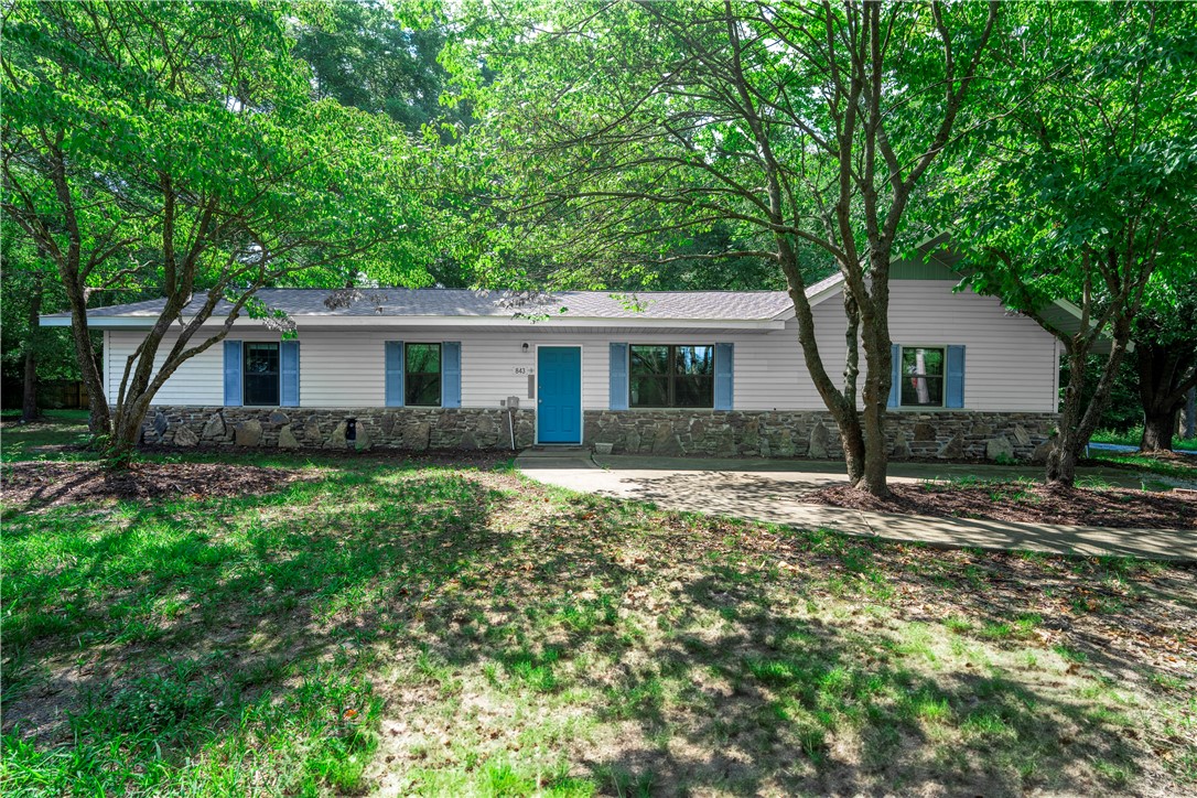 Updated ranch house in Goshen. Move-in ready with many recent upgrades. 4 bed/ 3 full baths all on one level. French doors open to large family room with lots of natural light. Kitchen has new countertops, backsplash and appliances. Fantastic, spacious heated and cooled sunporch with tile flooring and a ceiling fan. Two primary suites both with ensuite baths. All bathrooms feature new sinks, toilets, flooring and exhaust fans. New roof and water heaters in 2025. LVP flooring with new carpet throughout. Oversized 1/2-acre lot offers privacy with trees and expansive concrete patio. Convenient location just 7 miles east of Fayetteville and 16 miles west of Huntsville and not far from Mill Branch Park and the White River.