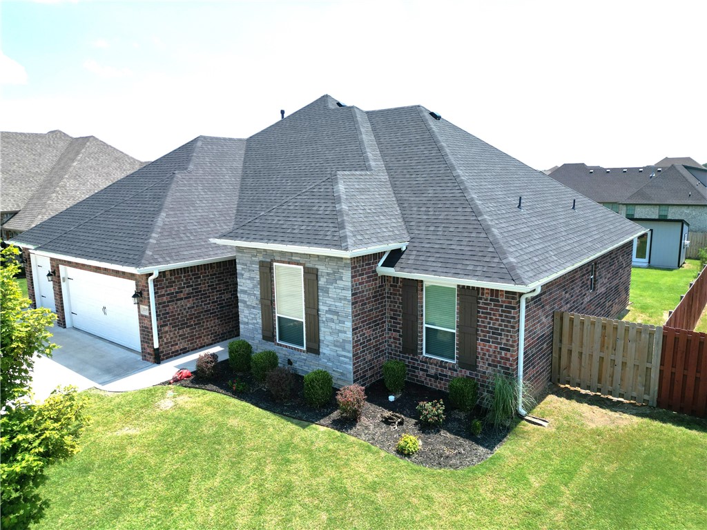 Welcome to this beautifully maintained 4-bedroom, 2.5-bath home in phase 1 of South Pointe, in the heart of Tontitown! Built by North Rock Builders, this 2,164 sq ft home features an all brick and stone exterior with elegant up-lighting and a 3-car garage. Inside, enjoy a split floor plan with high ceilings, crown molding, a cozy fireplace, granite countertops, pantry, and a seamless flow into the living, kitchen, and dining areas. The spacious primary suite includes a tray ceiling, walk-in shower, soaking tub, and a separate laundry room nearby for convenience. Wood, tile, and carpet flooring throughout, plus ample storage—including extra attic space. Step outside to a covered back porch, along with a stunning curved patio, with room for a hot tub, a fire pit, and an extra seating area. Off of the patio, a beautiful walkway with designer stepping stones and black rock leads to a insulated shed that can be heated/cooled—perfect as a workshop, gym, or studio. This home has it all—comfort, style, and functionality!