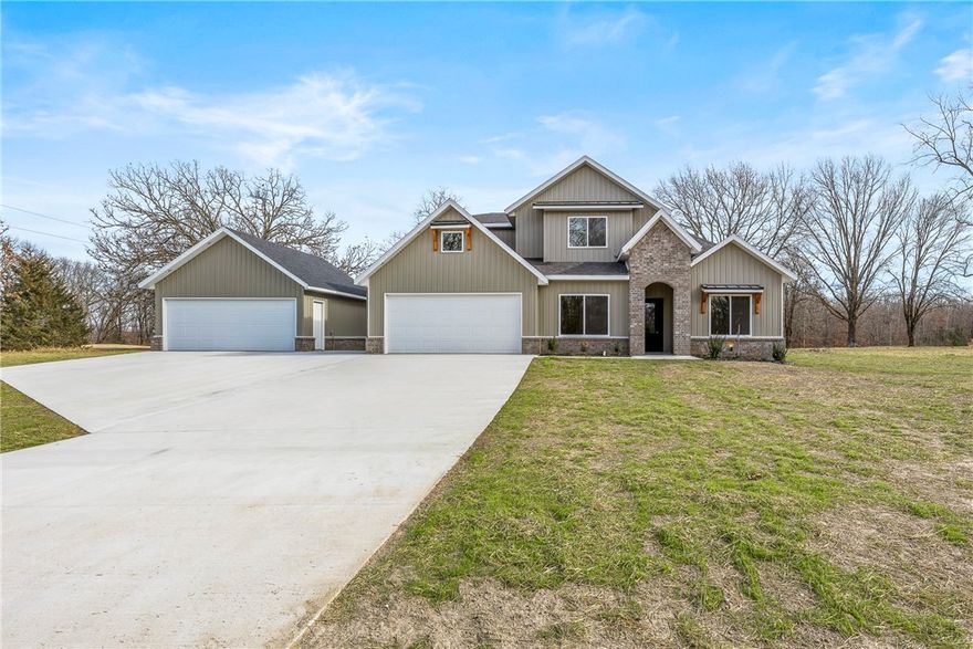 Gorgeous new construction home on a spacious 2-acre lot, offering an enviable location that backs right up to Big Sugar Golf Course. The home’s convenient setting provides easy access to Rogers, Bentonville, Beaver Lake, and all the amenities of Northwest Arkansas. The home boasts an open-concept living area and a large chef's kitchen complete with a giant pantry. The expansive first floor includes the luxurious primary suite, which features a spacious closet accessible from the opulent bathroom, which, in turn, flows directly into the laundry room. Also, on the first floor is another bedroom, full bathroom and an extra room perfect for an office or bonus room to be used as needed. Just outside the back porch is the golf course.  Upstairs are 3 bedrooms and a full bathroom.  The spacious front yard and driveway allows for lots of parking and play area.   Don’t miss the second 2 car garage/shop (20 x 24) for all the toys and tools. Septic system is for a 4 bedroom.