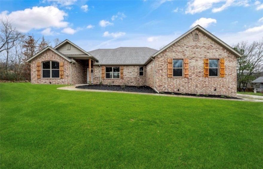 Stunning 2023-built home on a corner lot in Bentonville School District. 3 bedrooms, 2 baths, and 2,032 square feet. This split-bedroom floor plan blends modern comfort with everyday functionality.

Open-concept living, dining, and kitchen area filled with natural light and elevated finishes throughout. Hardwood floors and gas log fireplace create a warm focal point. Kitchen boasts granite countertops, custom cabinetry, a spacious pantry, and a large island.

Primary suite features a spa-inspired bath with dual vanities, custom tile shower, soaking tub, and a walk-in closet that connects to Laundry Room. 

Covered Deck overlooking a flat, usable yard — perfect for relaxing after a ride or hosting friends. Garage features tall ceilings and space for bikes, tools, and all your outdoor gear.

Located mins from Bella Vista’s Mountain Biking Trail Systems and NEW Bike Lift access, this home is a dream basecamp for outdoor enthusiasts. Quick access to trails, lakes, golf, and everything that makes NWA so special!