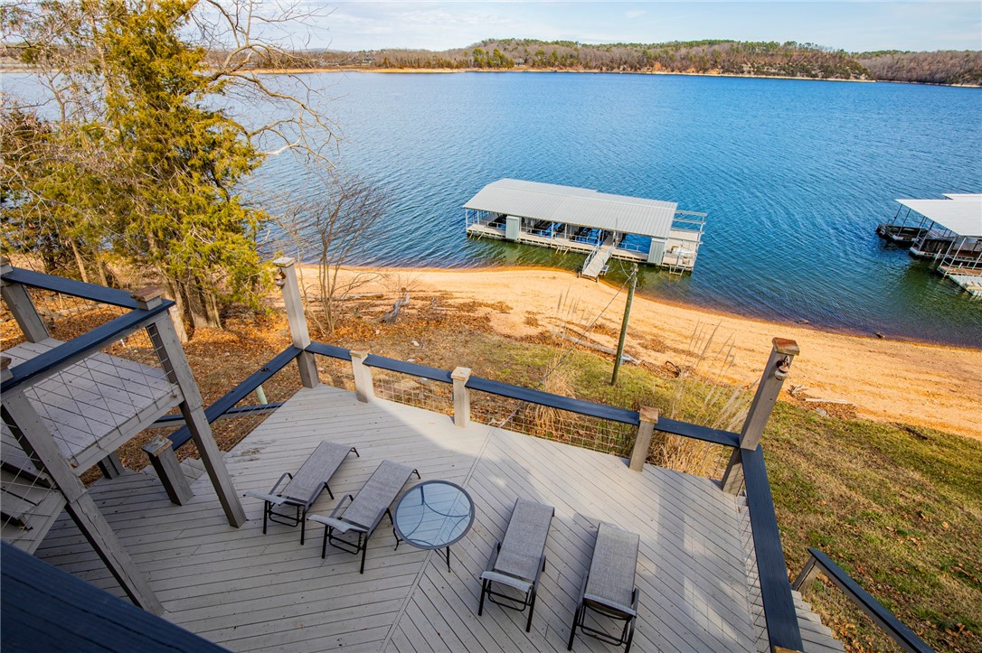 Sensational forever views, a stoneās throw from the shoreline and your own 4 slip dock with electric, 2-10X30 slips with lifts, 2-10X26 slips one with lift, 8x30 swim deck and only 7 miles to downtown Rogers. Turnkey and ready for you to air bnb or for your family and friends to create everlasting memories in. This lake home is packed with a punch and appeal like wood planked and beamed ceiling accents, open main level living lined with windows showcasing the million-dollar views, stunning entertaining space inside and out, second living space in walk out basement and a cozy loft with even more lake views. Lots of updates and upgrades custom soft touch cabinets, new roof, gutters, new windows and tankless water heater, new septic, one HVAC is less than 10 years old and the other is less than 5 years and the list goes on. This is a must see, all furniture and most furnishings and appliances (except for lower level refrigerator and freezer) stay, all you need is your boats and belongings. Come live the lake life!!