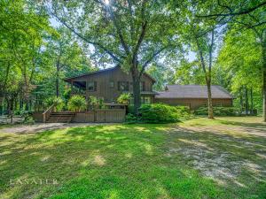 An entertainers paradise! You truly have to see to believe the beauty of this property. You will be in awe from the moment you drive down the private lane situated along the 25 manicured acres! The home features a beautiful two story cedar-sided traditional home with double wraparound decks, 3 bedrooms (optional 4), 3 full and 3 half baths, and hardwood floors. Equally spectacular is the beautifully landscaped, peaceful, outdoor living area which boasts a rock waterfall feature and lovely stream, a large open, tree covered seating area, large pavilion, outdoor kitchen, a half bath, and a sunken hot tub in the back deck. Must have a 24 hr notice for showing.