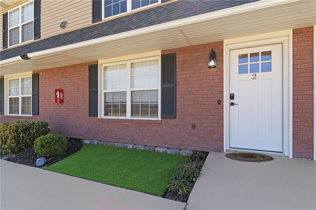 Front entry with a craftsman-style door, brick ven