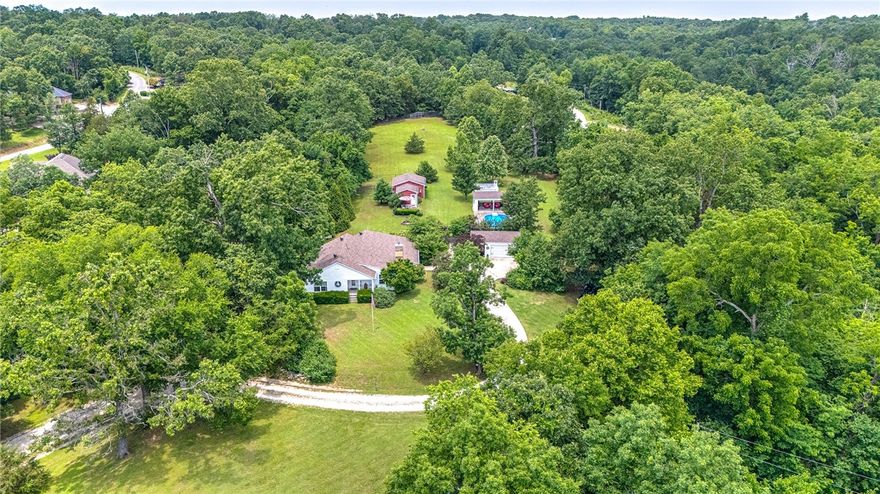 Pull up to your private oasis in Bella Vista, with NO POA RESTRICTIONS! This lovely and pristine property overlooks the 2nd hole on Scotsdale Golf Course. Surrounded by lush trees and so much peace! This New England inspired farmhouse cottage is stunning, with it's two office areas, large and open living room and kitchen and SO much natural light. Spacious and cozy bedrooms with large windows, ample closet space for you, your family and guest. The land is stunning with its pool and open cabana, turn key barn, above ground garden, barn with usable indoor space and firepit. Two covered porches and a pea stone courtyard too! Animals are permitted! Land uses are abundant from hobby farm to a new subdivision to your own special retreat. Imagine living in the center of Bella Vista, with ALL of this! So many options to make this charmer your very own. This one is so special!