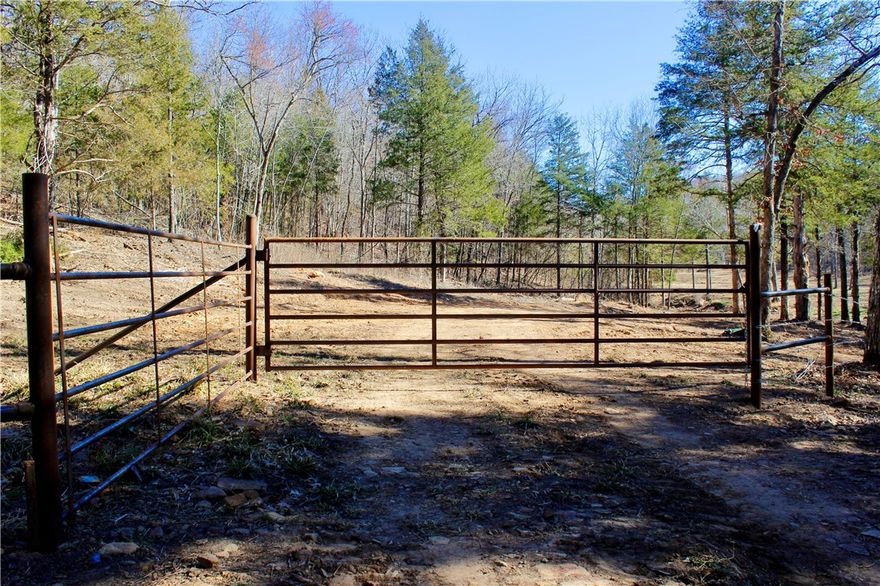 242+/- surveyed acres offers privacy, water, and breathtaking views. Tucked away behind a one-mile legal deeded easement from a gravel road, this property has seclusion without sacrificing access. A year-round creek winds through the land, with several other springs. Water storage tanks and buried water lines fed from a spring are already in place, adding options for future improvements. With about two miles of internal roads make navigating the property by truck easy, leading you to multiple build sites or hunting locations with stunning mountain top views. The land offers exceptional hunting with abundant deer and turkey, and even bear have roamed the area. Numerous locations provide outstanding food plot potential, enhancing wildlife habitat even further.  Topography creates natural funnels, benches, and bedding areas that serious hunters will appreciate. Conveniently located just 35+/- minutes from Huntsville, Arkansas and about 35+/- minutes to the iconic Buffalo National River near Steel Creek Campground.