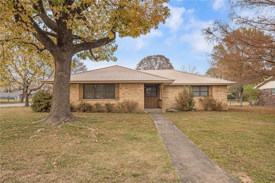 Welcome to this move-in-ready, classic 3-bedroom, 2-bath home on a spacious corner lot with great curb appeal and a side-entry 2-car garage. This property blends the charm of an established neighborhood with the benefit of major modern updates. Inside, the custom kitchen (2020) features new countertops, a farmhouse sink, and a stainless gas range. Both bathrooms were updated in 2022 with new fixtures, vanities, and tile work for a clean, contemporary look. Major system upgrades include a new HVAC (2022), tankless water heater (2022), and a durable metal roof. With the heavy lifting done—from kitchen and baths to the mechanical systems—this home offers an ideal mix of character and comfort. Don’t miss this updated gem in a convenient location with easy access to local schools and Don Tyson Pkwy.