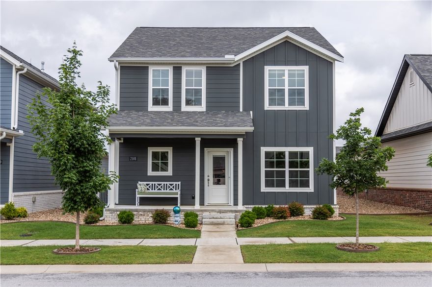 Ideally situated 2 miles from the Bentonville Square, this amazing property is easy living and low maintenance. Lawn mowing and edging is included in the POA dues as well as manicured common areas, access to an event pavilion, pickle and bocce ball courts, and a gated dog park.  This beautiful home is 3 years new and offers 1963 sf, 3 bedrooms AND a dedicated office, & 3 bathrooms. The owner has added a beautiful synthetic deck, a closed in sunroom between the home & garage with 2 oversized sliding glass doors and epoxy flooring. Both sides of home have pebble rock, sprinkler system in ground, a water filtration system, extended space in the garage, and add'l storage under the stairs.  Refrigerator, washer, dryer, and work bench convey with sale.  The primary bedroom and ensuite are oversized and tastefully done with a separate tub and shower, private commode, and a huge walk-in closet. Range in kitchen as well as fireplace are electric but also plumbed for gas. Seller prefers to not close until end of July.
