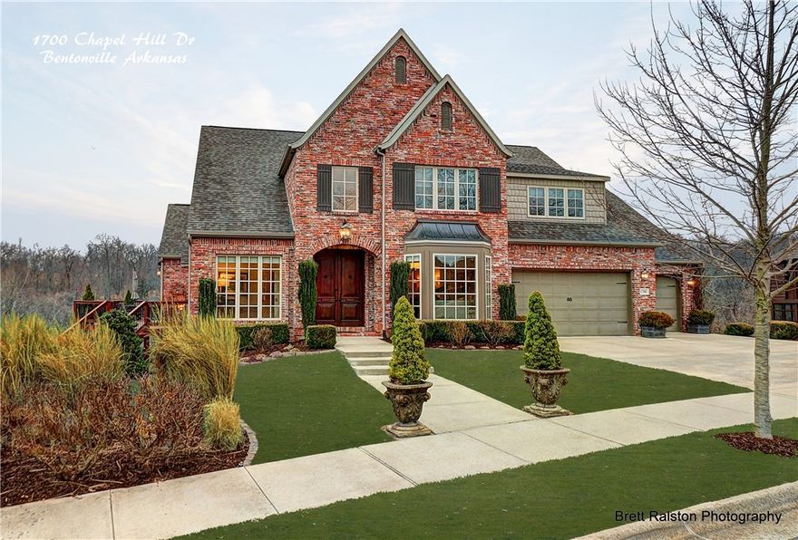 Through the front antique doors with European embellishment, this area transitions into a grand foyer that leads into a large living area with massive windows. Beautifully proportioned rooms create both cozy informal living areas & easy flow for larger affairs. Three levels of living space offer 6 spacious bedrooms, sitting areas, 4 full baths/1 half. Some additional features include: finished lower lever with family room, kitchen, exercise/craft room, game room, in-law suite, two levels of wrap around decks for unlimited outdoor enjoyment & entertaining. Home is located blocks from downtown, walking/riding trails, & Crystal Bridges. This Estate lacks for nothing, with its open vistas & private spaces, making it the right home for the most savvy and discerning buyer