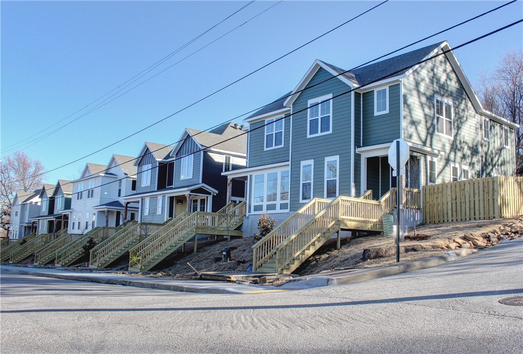 New architecturally designed town home located blocks from the Fayetteville Downtown Square and Dickson Street entertainment. Spacious eat-in kitchen includes an eating bar, with custom built cabinets, quartz countertops, large space for dining table or additional sitting area, separate living space, guest half-bath, high main-level ceilings, covered front porch, landscaped and 2 cars of off-street covered parking. This unit is located on the corner of Dickson and Fletcher. *AGENT OWNED*