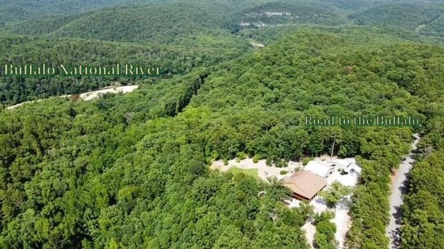 This  property  borders the National Buffalo River Park. The floating input is just a half mile away.  Property is fenced with gates at the paved road and landscaped with gravel for plenty of parking.  It has B & B potential and outdoor activities   The RV garage has fully furnished  460 sq ft apartment . Maintenance is low with smart no paint siding with lifetime warranty, stone, and metal exterior.  Upon entering the inside you view soaring rock fireplace, gorgeous pine, cedar, walnut walls, custom  cabinets , hickory floors, tile and LVP for easy maintenance. Storage  is fantastic with utility and pantry off kitchen. In master bed and bath : his and her closets, copper sinks, walk in jacuzzi & shower, There are beautiful views from windows and decks overlooking forest and raised bed gardens with paths through fruit trees, perennial flowers, roses, Dogwood trees and  sidewalks all around. Covered storage for any equipment,  storm shelter and more room for outdoor gear or decor, equipment, garden tools and more.