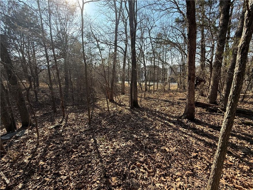 3.28 Acres Near Fayetteville Square & the University of Arkansas! Tucked away in a quiet setting off E. Huntsville Rd. (Hwy 16 East), this property offers both privacy and convenience while being walking distance to Happy Hollow Elementary School and the Mt. Sequoyah Trailhead. Featuring beautiful natural surroundings with deer frequently seen throughout the property, adding to its peaceful, secluded feel despite being in town. Utilities available at the street, and current RSF-4 zoning allows for up to 13 single-family homes, creating an excellent development opportunity. Whether you’re looking to build multiple homes, invest in a residential project, or create a private estate, this property offers incredible flexibility and would make an ideal family compound with plenty of room to build several homes together while still enjoying space and privacy. Opportunities to acquire this much beautiful acreage in the middle of town are extremely rare.