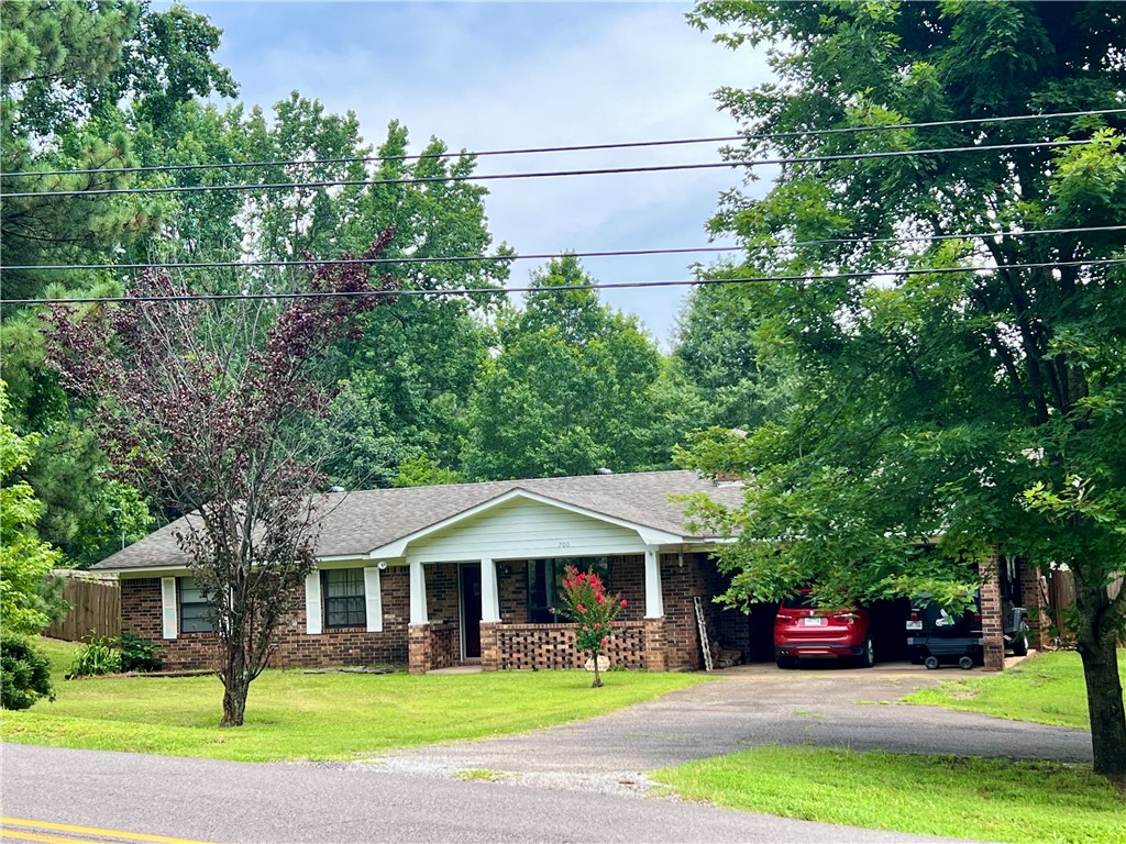 Enjoy this beautiful tree covered over 1/2 acre Corner Lot in the City limits of Clarksville that offers This brick home with a fully privacy fenced backyard. This lovely home offers three bedrooms, two baths and an oversized laundry room with access to your covered back porch. Enjoy the open floor plan with large windows and a Brick fireplace in your living room. Attached 2 Car Carport with Storage room too. Asphalt circle drive makes for more parking and convenience. Excellent location to the City of Clarksville or the University of the Ozarks. Call for your showing appointment today!