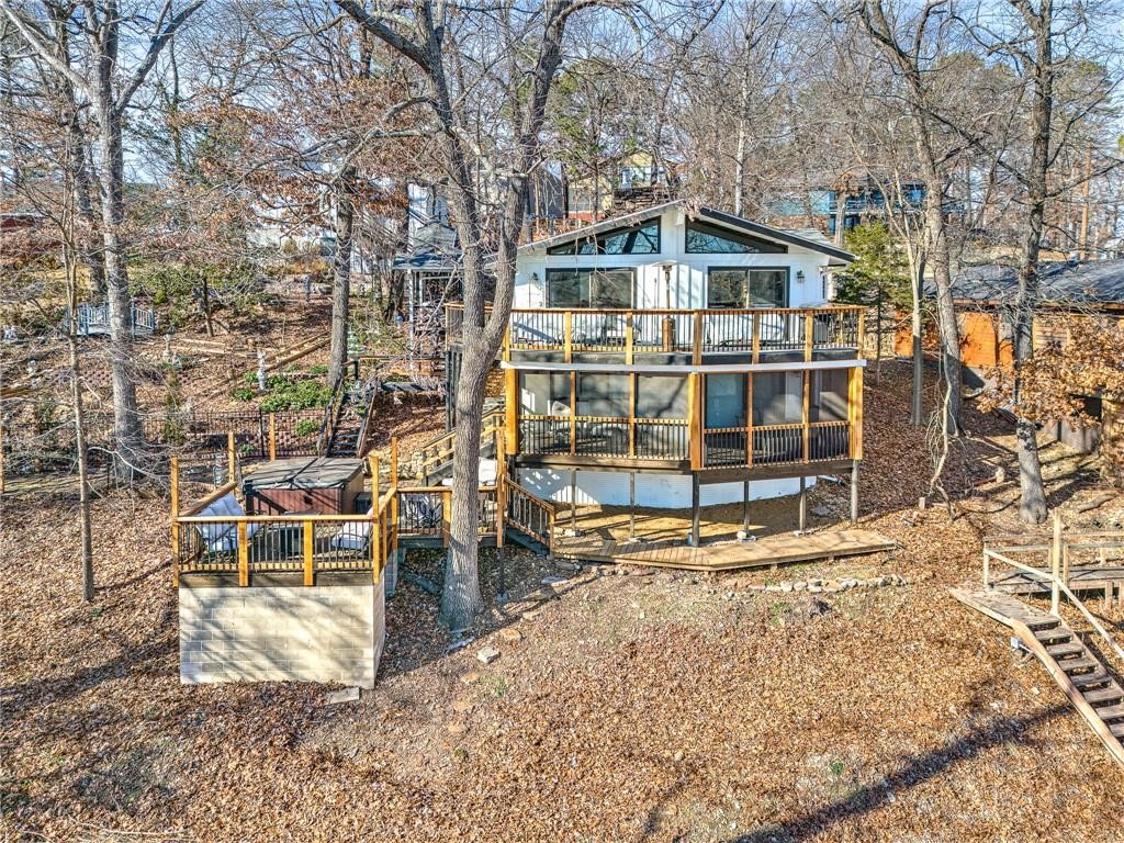 Escape to the enchanting beauty of this lakeside haven, perfectly situated on a lush 1-acre wooded lot. Fully remodeled in 2022!! Whether you dream of owning your own private lake sanctuary or desire a lucrative Airbnb investment, this property offers a unique blend of natural serenity and modern luxuries. The lush surroundings create a picturesque backdrop for your lakeside retreat. Enjoy direct access to the pristine Beaver Lake with your own private boat slips. The 2-slip dock, ensures that all your watercraft are easily accessible for a day of lake adventures. Indulge in ultimate relaxation with your very own hot tub. Situated to capture scenic lake views, the hot tub provides a perfect spot to unwind after a day of water activities. The furniture and boat lift do not convey.