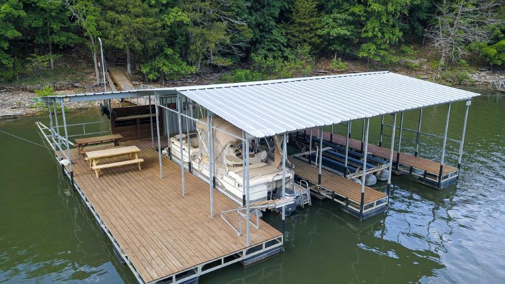 Major Remodel/addition in 2019. Lake views year-round from this rustic lodge-style home, minutes from Rogers. The upper level with vaulted ceilings that integrates the living room featuring a fireplace with the dining area and kitchen with a pantry. Comfortable 3 bedrooms, office with a scenic deck, three full baths, guest powder room. Master bath has walk-in shower. Appliances and 4wd UTV are included. Walk-out lower-level features game room, TV room, ¾ bath, storage areas and small exercise area. 2+car garage includes a workshop & ATV parking, storm shelter and large driveway with additional parking space. Private lake access via 4WD ATV trail leading to lighted parking area. The private 2 slip dock is equipped with electricity, a 4,000 lb boat lift and swim deck. Safety and convenience are prioritized with exterior lights that can be controlled from both the parking area and the house itself. Furnishings are negotiable.