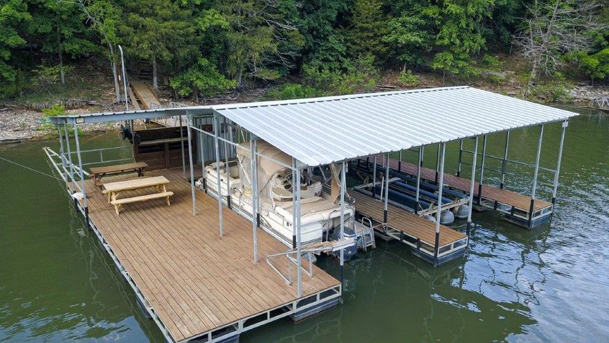 Major Remodel/addition in 2019. Lake views year-round from this rustic lodge-style home, minutes from Rogers. The upper level with vaulted ceilings that integrates the living room featuring a fireplace with the dining area and kitchen with a pantry. Comfortable 3 bedrooms, office with a scenic deck, three full baths, guest powder room. Master bath has walk-in shower.  Appliances and 4wd UTV are included. Walk-out lower-level features game room, TV room, ¾ bath, storage areas and small exercise area. 2+car garage includes a workshop & ATV parking, storm shelter and large driveway with additional parking space. Private lake access via 4WD ATV trail leading to lighted parking area. The private 2 slip dock is equipped with electricity, a 4,000 lb boat lift and swim deck. Safety and convenience are prioritized with exterior lights that can be controlled from both the parking area and the house itself. Furnishings are negotiable.