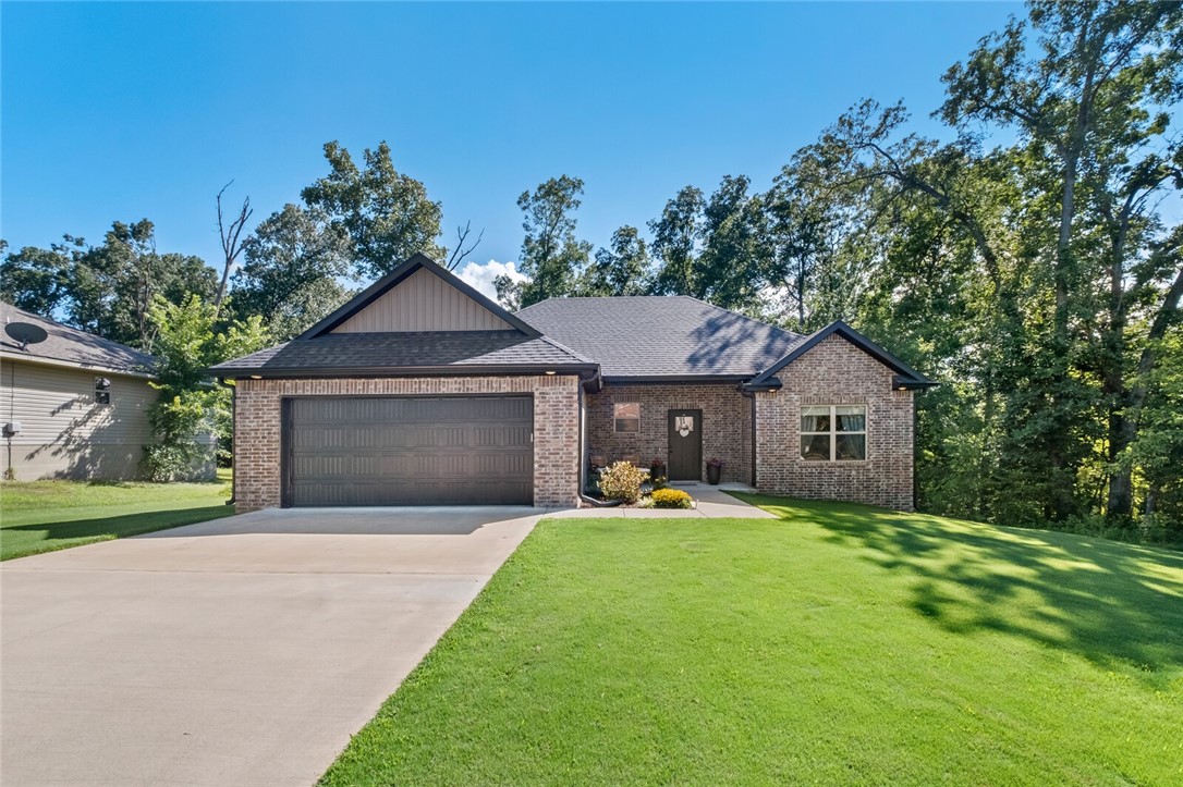 This one-level, 3 bed, 2 bath home features a light & bright open floor plan. Enjoy a spacious level yard/driveway and a charming covered front patio. The living room offers high ceilings, wood-look laminate flooring, a fireplace with a stone surround to the ceiling, and a serene view of the tree-lined backyard. The eat-in kitchen is complete with quartz countertops, white cabinets, upgraded gold-toned hardware, subway tile backsplash & a pantry. The primary suite includes dual walk-in closets, a tiled shower with framed glass doors and framed mirrors over a dual sink vanity. The front bedroom has a vaulted ceiling and large window—perfect for an office. The guest bath includes a linen closet. Added perks: mudbench, 2-car garage with attic storage, insulated garage door, gutters with leaf protection, and a mostly level tree-lined backyard. Quick I-49 access. Enjoy all that Bella Vista has to offer including mountain biking trails, clubhouse, pool, golf and lake Loch Lomond is nearby for fishing and kayaking.