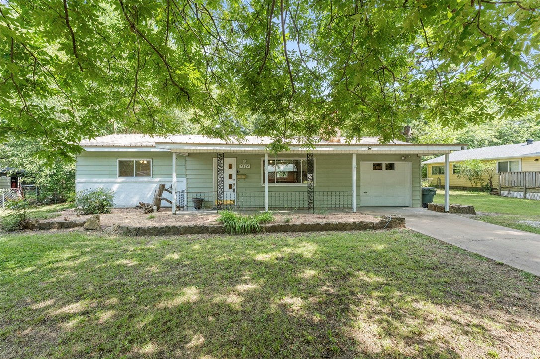 Location! Affordable convenience just 4 minutes from the University of Arkansas with easy access to I-49. This home is also close to the new police and fire station. The large, flat backyard features mature trees that create natural privacy along with a fire-pit area for relaxing or entertaining. Other features include an extra storage room in the garage, an extra gravel parking space, and a long covered front porch that provides the perfect spot for morning coffee. Recent updates include a new HVAC system (2024), dishwasher (2024), water heater (2022), and a durable metal roof.