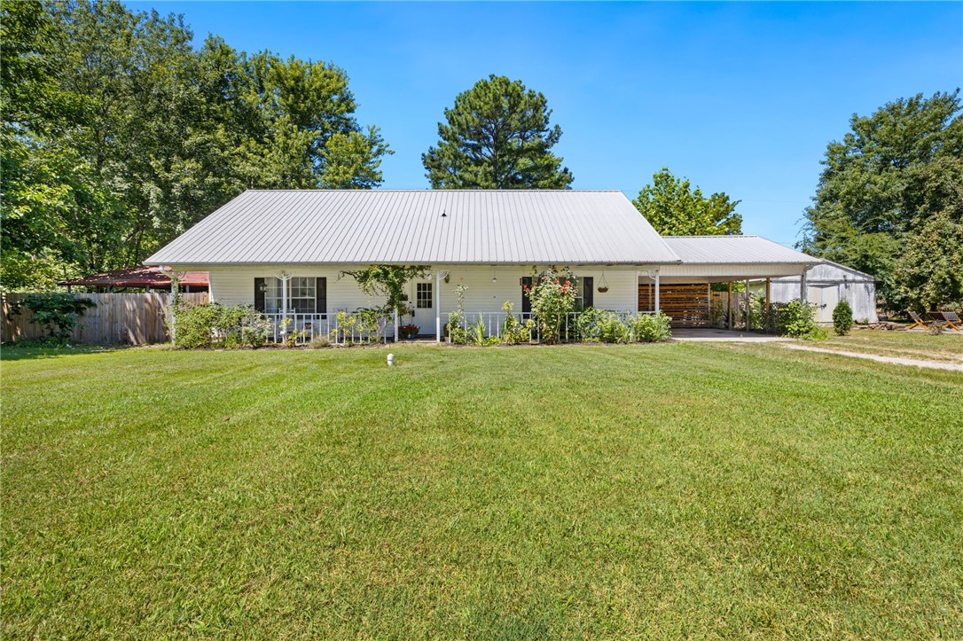 Welcome to this inviting and uniquely designed single-family home nestled on a generous 0.75-acre lot in a convenient Fayetteville location! Just 5.5 miles from the University of Arkansas and the Historic Downtown Square, and with quick access to I-49, this home offers the perfect blend of peaceful living and urban convenience. Step onto the charming covered front porch and into a home full of character. Inside, the layout features two bedrooms and a full bathroom on the main floor, with a third bedroom and additional full bath upstairs, ideal for multi-generational living, guests, or a private home office space. Enjoy outdoor living with a large concrete covered patio near back and side of the home, perfect for entertaining, relaxing, or taking in the natural surroundings of your spacious yard. A detached shop building sits on the property with great potential for a workshop, studio, or additional storage, it will need some TLC but offers plenty of possibilities. This home offers flexibility, location, and value.