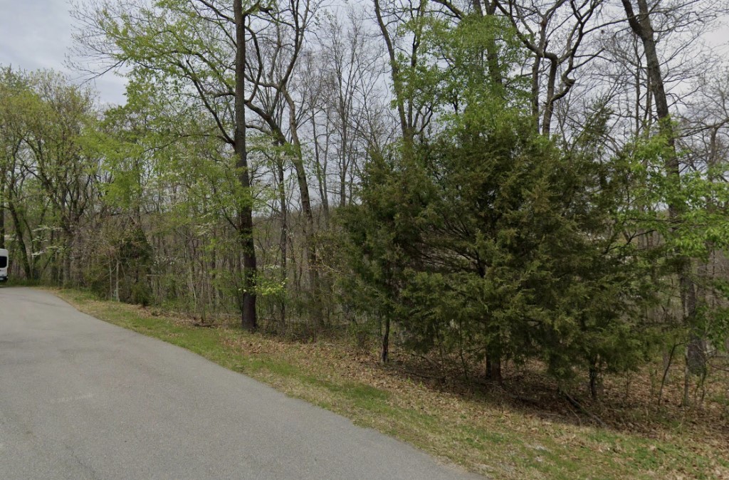 Nestled in a quiet cul-de-sac, this wooded lot (Parcel ID: 16-04119-000, Coordinates: 36.474916, -94.212041) offers peace, privacy, and prime location near Lake Ann and the Back 40 Trails. Located in the sought-after Bentonville School District, it's ideal for families or investors seeking long-term value. Winter lake views add seasonal charm and potential appreciation. A recent perc test confirms suitability for a three-bedroom home with 300 linear feet of field lines required for a standard septic system. Whether building a custom home or investing in Bentonville’s growth, this lot blends natural beauty with development-ready potential.