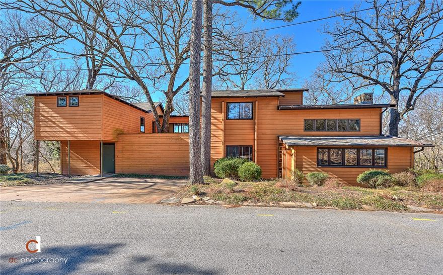 This uniquely designed contemporary retreat is nestled on a .52 acre corner lot boasting spectacular views with multiple outdoor living spaces ideal for entertaining and enjoying the beautiful and private landscape all within walking distance to the U of A campus and Razorback Stadium plus just 2 miles from I-49 allowing you fast access to all of NWA!  Fabulous architectural elements throughout the 3 levels of living space including expansive windows, floating staircase, vaulted beamed ceilings, amazing courtyard that is a true extension of the home, exceptional walk-in closets, beautiful sun-filled catwalk to the newer addition owner’s suite on the second level, home office, spacious eat-in kitchen w/ large island, Juliet balconies, sunroom, 3 of the 4 bedrooms offer private en suite baths, 4th/guest bedroom on main level, amazing pantry and hobby/craft room, and more!  A must see home in one of the best locations in Fayetteville!