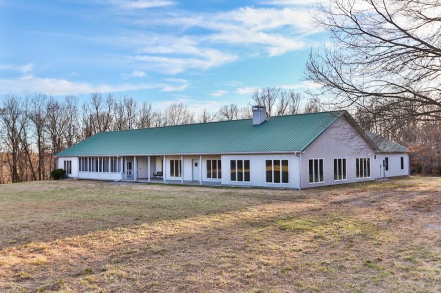 End of the road privacy & seclusion on 53 acres just outside Elm Springs. Strong durable construction w/metal siding & roof.  Floor plan boasts 2 wings. Main wing with 3BR-2BA-3 car garage w/2 living areas. Master w/walk-in closet, whirlpool tub & separate shower.  Granite counter tops. 2nd wing can serve as in-law suite w/2BR-1BA. Tile floors. 5 car garage. Can be handicap accessible w/few modifications. Mostly wooded. High-end back-up propane generator. Owner financing available. Great family compound!