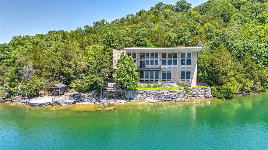 Unparalleled lake views. Private boat launch. Boat slip on community dock. Gorgeous home. This one-of-a-kind lakefront retreat on 1.42 acres along Beaver Lake checks ALL of the boxes! With nearly 3,900 sq ft, this custom-built home features gorgeous Austin Stone, 3 bedrooms, 4 baths, and soaring 11-ft ceilings on both levels, as well as unfinished space that can add to your square footage! Floor-to-ceiling windows flood the home with natural light and frame breathtaking views. Designed for both relaxing and entertaining, enjoy multiple living areas with cozy fireplaces, a chef’s kitchen with custom wood cabinetry, and an outdoor kitchen with full utilities—perfect for sunset dinners. Whether you're launching your boat from your private ramp, using your covered slip with lift, or just soaking in the peace and privacy, this home delivers the ultimate lake lifestyle. Ideal as both a full-time residence or serene getaway—luxury lake living starts here!