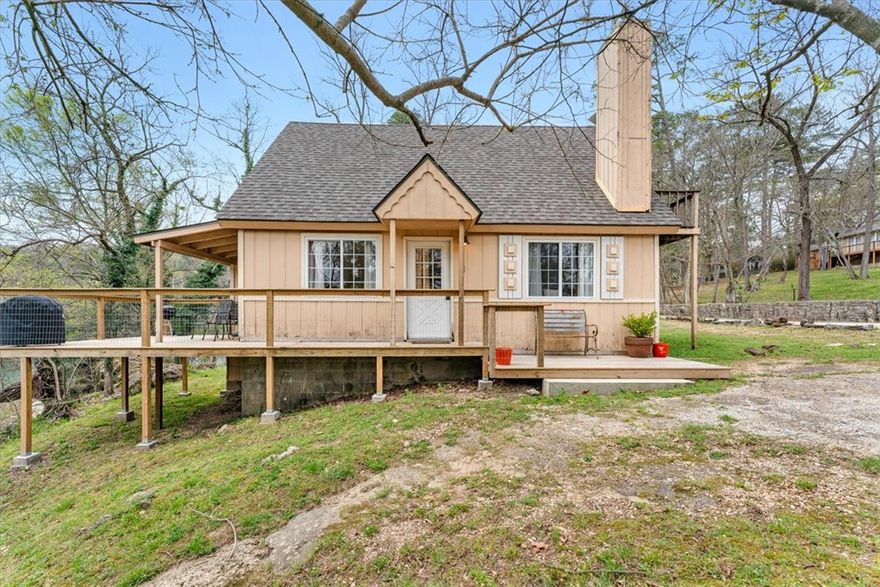 Dandelion Cottage at Lake Lucerne - a storybook retreat minutes from downtown Eureka Springs. This charming English-inspired cottage overlooks the tranquil waters of private Lake Lucerne. Inviting living room features a gas fireplace and large windows that frame the surrounding woods and water. The lakeside deck sits just off the living area. A serene bedroom on the main floor overlooks the deck and lake. A dedicated whirlpool tub room offers a spa-like escape with a picture window showcasing trees, rock formations and the lake! The upper level has a spacious bedroom with an adjoining sitting room. A 1/2 bath and private deck complete the second floor. New roof! Whether used as a personal getaway, vacation rental or full-time residence, this cottage offers a rare opportunity to own a piece of the Lake Lucerne experience that is steeped in history! Commercially zoned, making short-term rentals a non-issue! The furnishings can be negotiated.