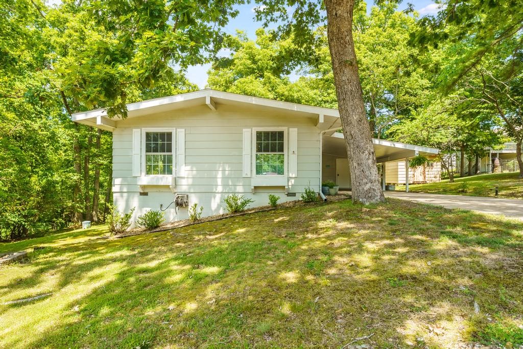 Welcome to 4 Crewe Lane in Bella Vista, AR. This 2-bed, 1.5 bath bungalow style home sits on a quiet cul-de-sac near Lake Avalon. Access the Lago Vista bike trail just a quarter mile from the house. The interior has been updated throughout. The eat-in kitchen features new countertops, new cabinet fronts, stainless appliances and tons of cabinet space. Right off the kitchen, access the deck which overlooks the backyard with views of the woods beyond the fence line. The living room is spacious and features a standing gas log fireplace that provides plenty of warmth in the wintertime. New flooring flows throughout the house. Bathrooms have been updated with new vanities, sinks, light fixtures, floors & tile in the shower. Extra storage available in the shed & in the large closet in the carport. Fridge, microwave, washer, dryer & shed (with electricity) conveys. Newer roof (2019). Blinds in bedroom & sliding back door can be opened from the top to provide privacy while allowing natural light to flow in.