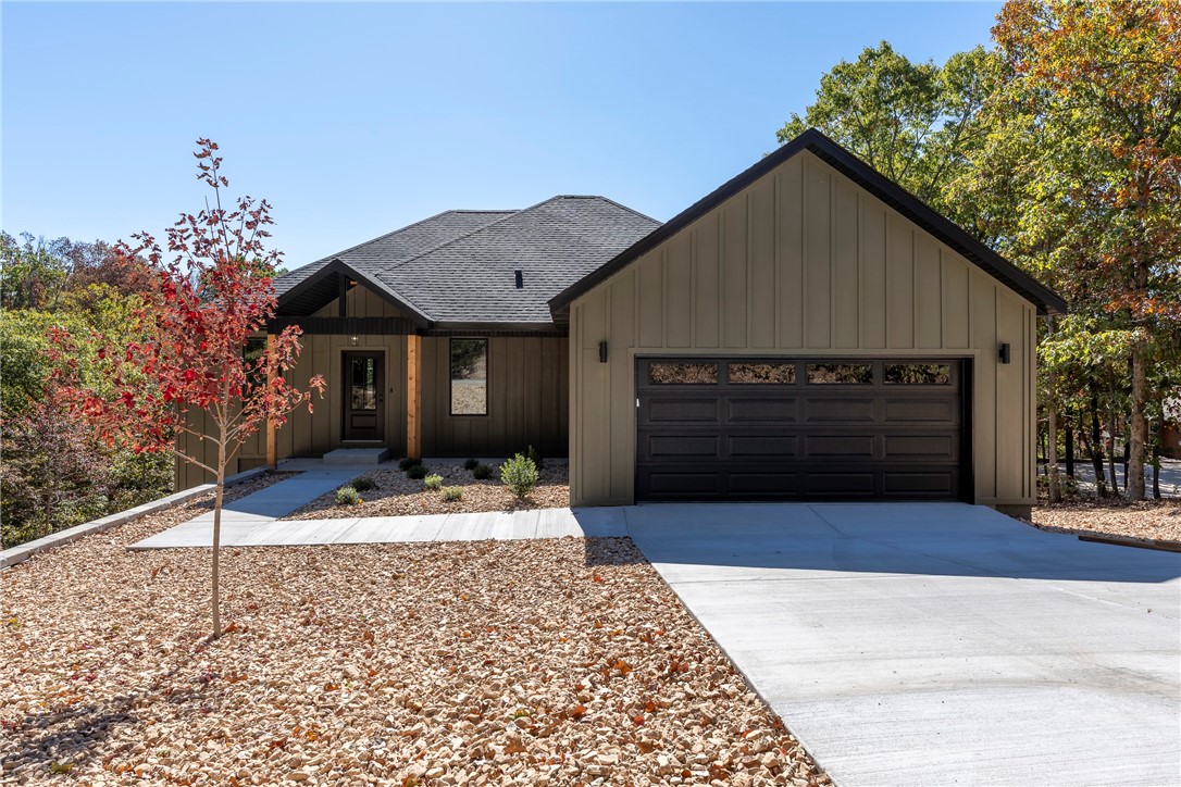 Low maintenance tree top view! This new construction home is situated right next to Loch Lomond on a quiet loop, offering a seasonal "peekaboo lake view" from its screened in back porch. This home has been professionally landscaped with rock (thatās right, no grass!) and thoughtfully designed with abundant windows to feel like you are living in the Ozark tree tops. The split floor plan has 3 bedrooms, 1 office, and two full bathrooms. Large closets with custom shelving, an electric fireplace, and walk in shower with custom glass + tile surround can be found. Black stainless steel appliances, custom cabinetry, quartz countertops, and walk in pantry bring a clean and elegant feel to the home. The exterior of the home features both Hardie board and batten and vinyl siding. A walk out crawlspace and an attic above the garage provide additional storage. A one year builderās warranty is included.