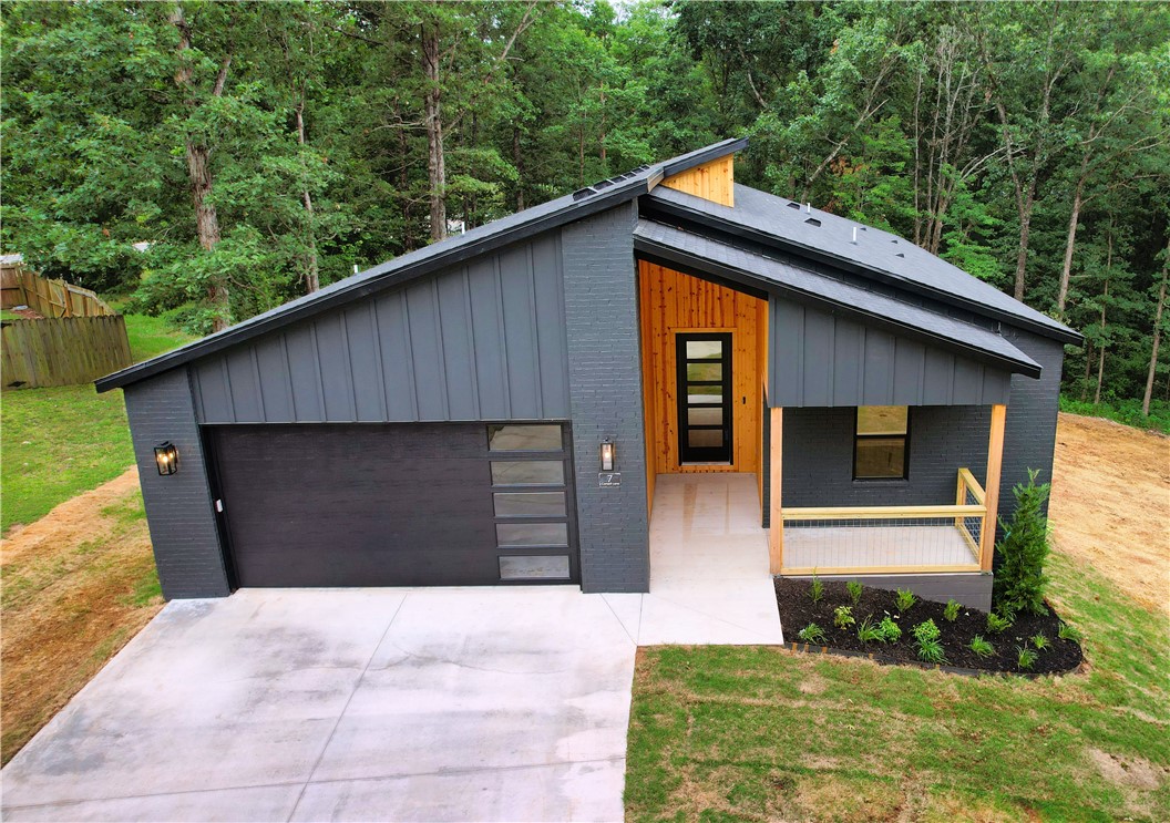 Adventure-ready living in Bella Vista! This brand-new 3-bed, 2-bath home offers the perfect fusion of thoughtful design & modern comfort. Conveniently situated on the scenic Back Forty biking trail, it’s a dream for outdoor lovers & low-maintenance lifestyle seekers alike. A natural wood entry (Car Siding) sets the tone for the bright, open interior featuring luxury vinyl plank flooring, a granite kitchen island, Frigidaire stainless appliances, a walk-in pantry, & a cozy dining nook. Designer lighting & a recirculating hot water system enhance year-round efficiency. You'll love the roomy walk-in closet, dedicated laundry room, & partially covered extended wrap-around deck overlooking the slightly sloping backyard. Plus, a partially walkable crawl space—perfect for bike storage or a workshop. Bonus: 2-Year builder warranty. Completed photos of interior are from an Iron Gate Construction home with similar layout and finishes.