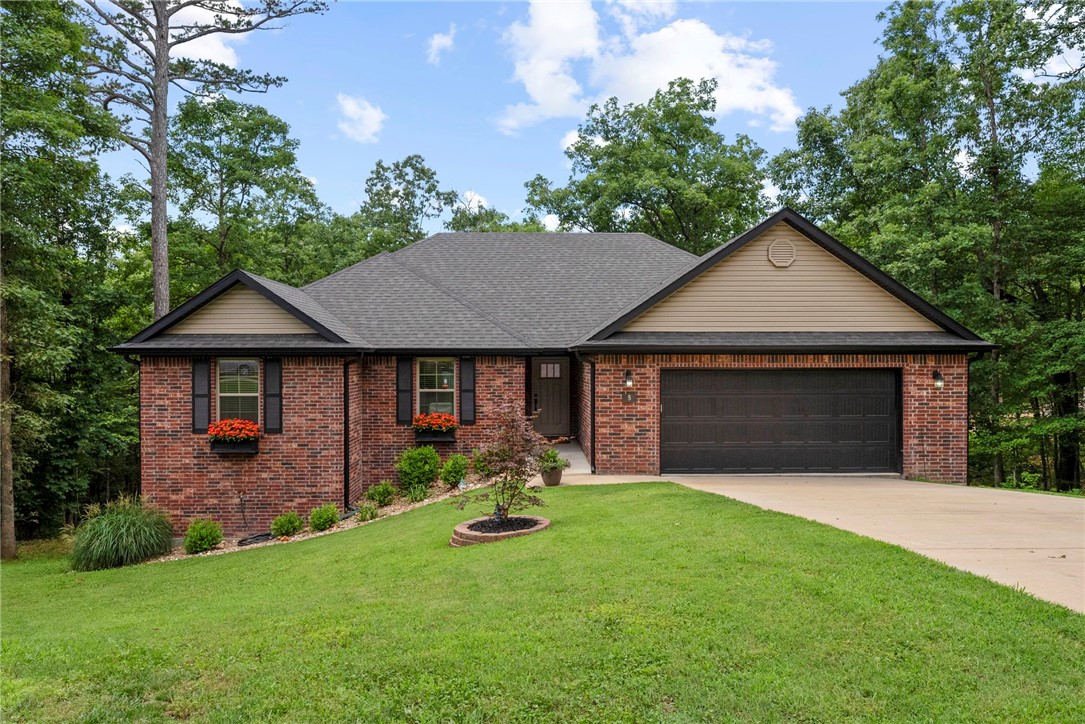 $2,500 credit provided by seller. Please ask about our preferred lender credit! Nestled at the end of a peaceful cul-de-sac, this beautiful home offers both serenity & convenience in the heart of Bella Vista. With easy access to the Back 40 & Flo Ride mountain biking trails & just minutes from Lake Norwood & Lake Ann, this location is an outdoor enthusiast’s dream. Step inside to discover an open floor plan featuring a stunning kitchen with a large island, granite countertops, & abundant cabinet space. Cozy up by the fireplace or step outside to the expansive covered back deck, offering shade & privacy with a beautiful wooded backdrop on a generous .38-acre lot. The primary suite is a private retreat with a luxurious floor-to-ceiling tiled shower & separate soaking tub. The home also boasts a well-appointed laundry room with extra cabinet storage & plenty of storage space under the deck.