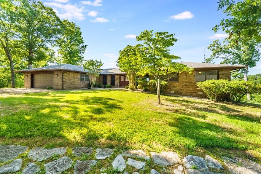 AMAZING location with year-round views of Beaver Lake! This single level, all brick home sits on a large, fairly flat, corner lot, just under a full acre. Beautiful views of Beaver Lake can be seen from the expansive deck, living room, sunroom & primary bedroom. The low maintenance composite deck can be accessed from the double sliders in the living room or from the sunroom. This home has been meticulously cared for by the same owners for the past 39 years. The kitchen has original features and is ready for you to update and customize. Natural light pours in thru the large front windows along the foyer hallway. All brick wood burning fireplace is at the heart of the living room. Oversized 2-car garage with room for storage & expanded driveway. Located less than a mile to Hwy 12 & 4 miles to Prairie Creek Marina. Roof was replaced 7-10 yrs ago. Recent updates: new heat pump (3 yrs), new toilets (5 yrs), shutters (3 yrs), wood flooring, sliding windows in back & composite deck.