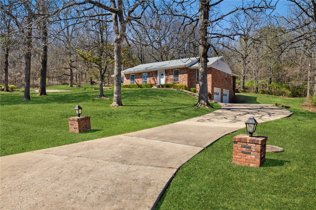 Tucked away on a serene, tree-lined lot in one of East Fayettevilleās most established neighborhoods, this warm and welcoming two-owner home offers the perfect blend of charm, character, and functionality. Set on 1.4 acres off of Crossover, the all-brick, single-level layout is timeless. Two private driveways provide easy access, including one leading to a spacious ~1,200 sq ft side-entry garage with a workshop and extra storage. Inside, pine wood floors, plantation shutters, & a mix of gas and wood-burning fireplaces create a cozy, inviting atmosphere. The kitchen features soapstone countertops and stainless steel appliances and connects to the den overlooking the peaceful backyard. The primary suite offers its own fireplace and a beautifully updated bathroom with marble counters and a walk-in shower. A private office with built-ins adds flexibility, while the oversized laundry/hobby room provides space for crafts, projects, or storage. This home has a quiet charm you can feel when you step inside.