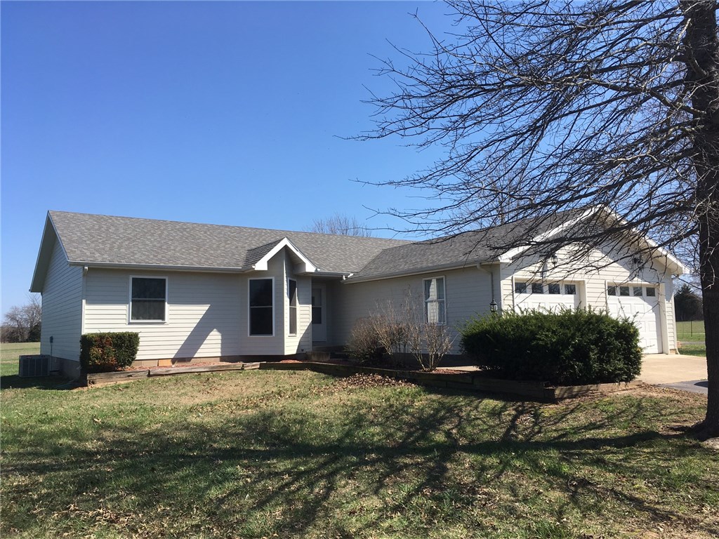 Charming, country home with LOTS of space and extras! This home sits in the middle of five acres. The long drive way is lined with fruit trees. The landscaped yard also features a Koi Pond with custom built water wheel. Heated and Cooled shop in back also has a half bath with two additional covered parking spaces. Storm Shelter is nice and clean. Large open living area and kitchen with walk around gas range stove. Ten minute drive to Beaver Lake. Property borders City Park with nice walking trail.