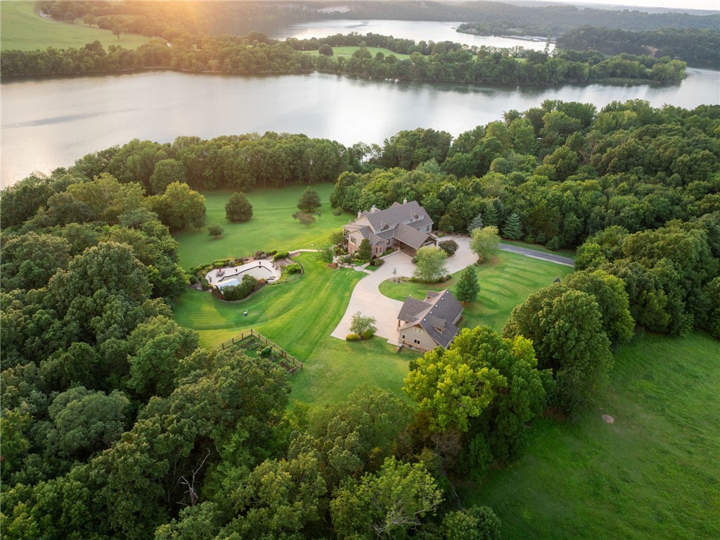 Discover your private lakeside sanctuary on the shores of Beaver Lake. Nestled behind a gated entry on over 10 acres, this stunning 6,300+ sq ft estate offers the perfect blend of luxury, privacy, and natural beauty. A winding driveway leads you to an impressive custom-built home featuring expansive living spaces, soaring ceilings, and panoramic views of the surrounding landscape.
Designed for entertaining and everyday comfort, the home boasts multiple living areas, a chef’s kitchen, and spacious bedrooms. Step outside to enjoy a resort-style inground pool, lush garden spaces, and serene lake access just moments away. The 3-car garage includes additional storage above—ideal for a studio, guest quarters, or workshop.
Whether you're hosting summer gatherings or enjoying quiet evenings by the lake, this extraordinary property is a rare find on Beaver Lake. Welcome to your dream retreat.