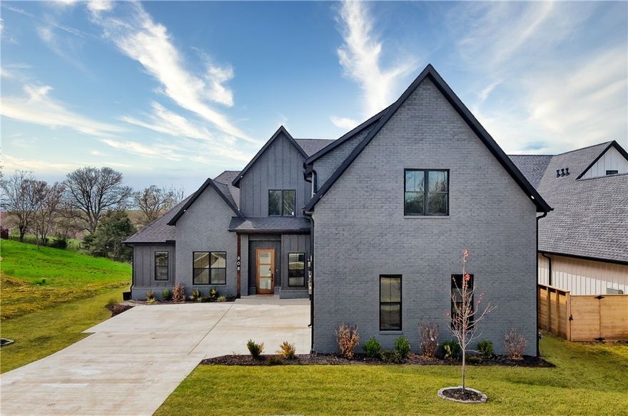 Welcome to one of the newest subdivisions in Northwest Arkansas! Located near Elm Tree Elementary, Coler Creek Mountain Bike Preserve and only 8 minutes from Downtown Bentonville, this stunning home sits on a .47 MOL acre lot on a quiet street. The open floor plan features 5 bedrooms, 3.5 bathrooms, a fantastic prep pantry next to a beautifully designed kitchen featuring granite countertops and upgraded appliances including a gas oven and range, and split refrigerator and freezers. Enjoy spacious room for entertaining indoors in the open-concept kitchen and living room with a beautiful gas log fireplace, or outdoors on the patio with a gas log fireplace that overlooks the backyard facing a wooded lot. The large primary bedroom is on the main floor with a  bathroom that features a rain shower, luxurious bathtub and a large walk-in closet with lots of built-ins. The main floor has 2 rooms that can be used as an office or bedrooms, a large laundry room and storage closet near the large 3-car garage.