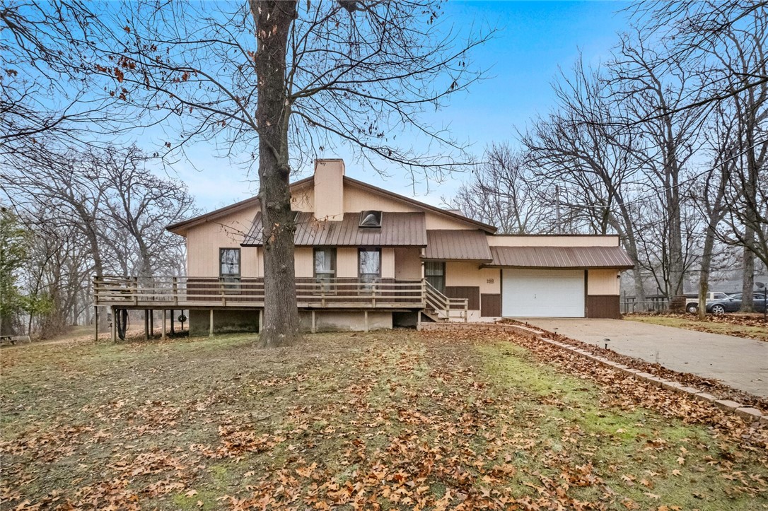 $10,000 in concessions with acceptable offer! This charming property offers nearly 1.5 acres of serene countryside living, just minutes from downtown Gentry & the city park. This home has had recent roof & skylight inspections & repairs. Inside, you'll find a spacious living room with stunning floor-to-ceiling windows & exposed wood beams, creating a bright & inviting atmosphere. The eat-in kitchen is equipped with ample cabinet space, perfect for all your storage needs. With cozy carpet & wood laminate flooring throughout, this home offers both comfort & durability. Enjoy the outdoors from the wraparound porch overlooking the pond, or entertain guests in the unique party room featuring a covered front porch running the length of the building, along with a pellet stove, hot tub, & a grill in the kitchen. For your convenience, the main house includes a refrigerator, washer, & dryer. The workshop has an air compressor that conveys, along with an additional parking spot. The property is ready for your next adventure!
