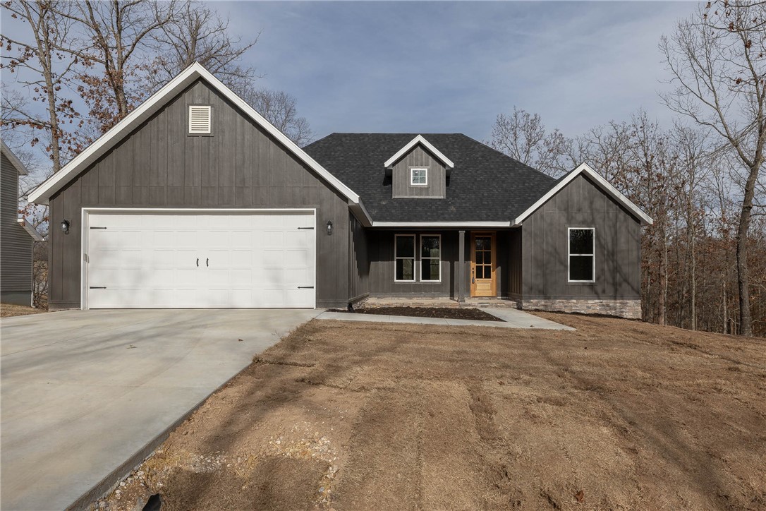Discover the charm of this new single-story ranch, an entertainer's delight. Hardwood floors, cathedral ceilings, and a fireplace grace the living room. The kitchen features granite countertops, a large island, gas stove, beverage nook and a walk-in pantry. The primary bedroom is a haven with a well-lit en-suite, split-vanity granite countertops, glass front walk-in shower, free standing soaker tub and a spacious walk-in closet, all accessed through a sliding barn door. The mudroom, connected to the garage, offers practical seating, hooks, shelving, and cubbies. Laundry room is a separate room off the garage and offers utility wash sink. Step onto the covered back porch, enjoy morning coffee or evening stars while soaking in nature's sounds. This home seamlessly combines modern living with natural beauty, providing a tranquil retreat in a well-designed space.