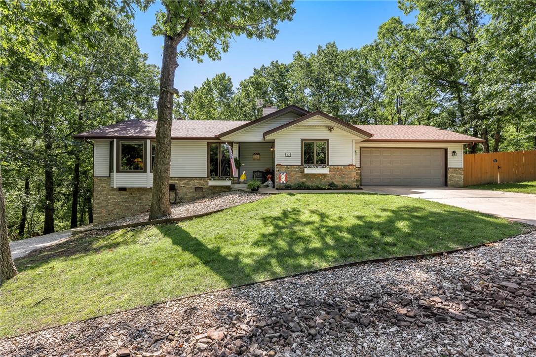 Tucked away in a quiet cul-de-sac near the Highlands & Scotsdale golf courses, this beautifully maintained 3-bedroom, 2-bathroom home offers the perfect blend of comfort, functionality, & serenity. Enjoy 1,696 sqft of thoughtfully designed living space on a generous 0.63-acre lot. Step inside to find warm wood flooring, bay roll-out windows w/ Valour Honeycomb shades in every room that flood the home w/ natural light, & a stylish kitchen ft. granite countertops. The heated & cooled sunroom provides a cozy, year-round space to relax & take in the peaceful wooded surroundings. Fully heated & cooled basement workshop offers the ideal setup for hobbies or projects, along w/ extra storage under the deck & in the basement. A water softener system adds comfort & convenience, while the gravel walkway surrounding the home adds charm & accessibility. With its tranquil setting, practical upgrades, & proximity to premier golf courses, this Bella Vista gem is ready to welcome you home. New Roof 2021. Septic cleaned out 2020.