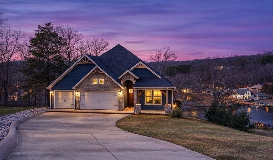 Now offered at $997,000—this Lake Windsor waterfront home with panoramic views and flexible multi-level living is newly positioned to align with today’s buyers. Set on a 0.62-acre lot with ~80 ft of lake frontage, this 3BR, 3BA home offers 3,694 sqft across two levels. The main level features vaulted wood-beamed ceilings, expansive lake-facing windows, and an open-concept great room ideal for entertaining. The primary suite offers lake views, a custom tiled walk-in shower, and a walk-in closet with direct laundry access. A second bedroom and full bath are also on the main level. The walk-out lower level includes a second living area, full kitchen, third bedroom, full bath, and flexible bonus space. Covered outdoor living plus additional lower-level storage for lake gear. Built in 2019 with tile flooring throughout and a 3-car garage. Enjoy lake living with easy access to Bentonville.