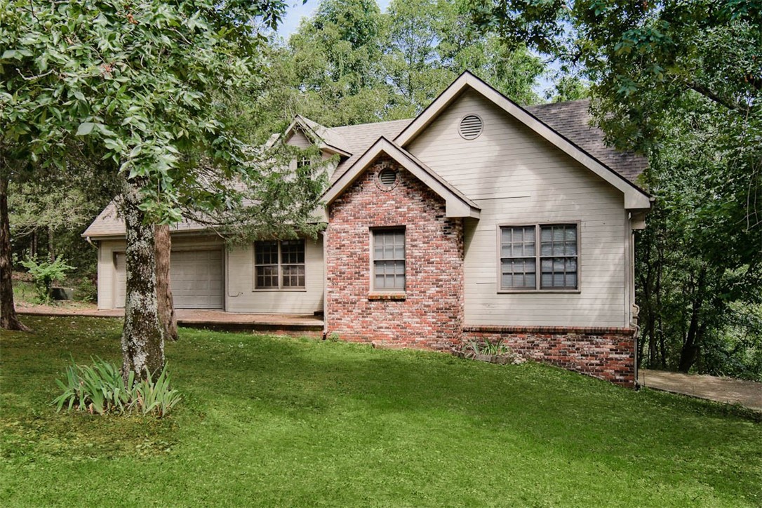 Experience the perfect blend of comfort and style in this beautiful 3-bedroom, 3-bath home that can also be used as two units. The lower level has its own entrance and parking, as well as a full kitchen and bathroom, making it a perfect opportunity to produce income out of the second unit. The upper level is a 2-bed 2-bath and the lower level is a spacious 1-bed 1-bath. The open living room features impressive vaulted ceilings. A spacious primary bedroom with walk-in closet provides ample convenience. The second living space downstairs offers versatility for entertainment or relaxation. Situated on a quiet street surrounded by trees, this home provides a serene retreat just minutes from downtown Eureka Springs. The exterior blends wood and brick siding, harmonizing with the natural surroundings. With a 2-car attached garage, ample storage, and a prime location close to downtown, this home combines comfort, convenience and income opportunities in one perfect package. Donāt miss out on this unique opportunity!