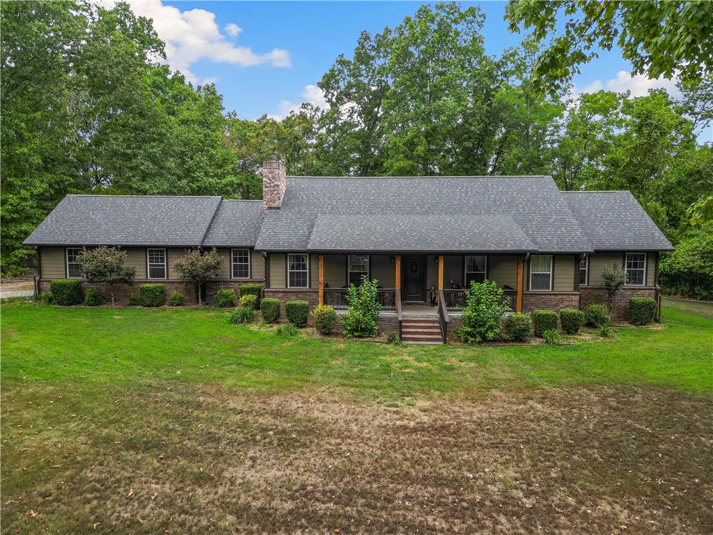 Discover your private retreat in this spacious 2,200 sq ft home, offering three bedrooms and three bathrooms. Nestled on 14.51 acres of beautiful, mostly flat wooded land, this property is ideal for nature enthusiasts and hunting aficionados. Lots of deer and even a few turkey. The home features a well-designed layout with ample living space, while the 1,200 sq ft metal shop adds exceptional value, complete with heating and cooling for year-round comfort. New roof just installed on both home and shop. Duel fuel heat pump helps with those cold winter nights. Wood burning fireplace insert is efficient. 500 gallon buried propane tank is owned and conveys. All appliances and most furniture can convey. The bonus room is currently being used as a gun room\dog room. This is a one of a kind property that will mesmerize you from the start. This property won't last long!!! If your looking for a property with a private setting just minutes from Pea Ridge that checks all the boxes be sure to come look at this one.