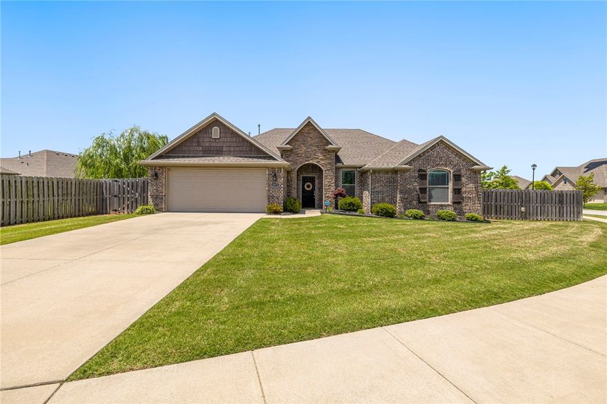 Welcome to this charming 3-bedroom, 2-bathroom home nestled on a spacious corner lot in the sought-after Villages of Sloanbrooke subdivision. Built in 2018, this 1,803 sq ft single-story residence boasts a thoughtful split-bedroom layout, offering both privacy and functionality. The living area has hardwood floors and a cozy gas log fireplace. The kitchen is equipped with granite countertops, a gas range, ample cabinetry, and a generous pantry. Each bedroom is generously sized and includes walk-in closets, with the front guest room showcasing a vaulted ceiling. The primary suite has its own en-suite bathroom. The backyard features a large covered patio pre-wired for a TV and a gas stub ready for your grill—perfect for entertaining or relaxing evenings. The backyard is enclosed with a privacy fence, providing a safe and secluded space. Sprinkler system added and new landscaping. Close access to community amenities such as parks, sidewalks, and nearby trails. Located 10 minutes to the University of Arkansas.