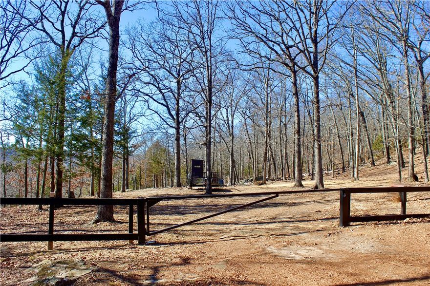 Discover an exceptional 40+/- acre surveyed tract offering natural beauty and privacy that’s becoming harder to find in Northwest Arkansas. Tucked just 1/2 mile from pavement, this property features a gated entry and easy access while still feeling worlds away. A level build site, sits perfectly positioned to capture stunning mountaintop views, making it ideal for a dream home, cabin, or recreational retreat. The land is richly diverse, highlighted by a creek, dramatic mature bluffs, and a seasonal waterfall that adds both charm and tranquility. Wide, flat, mature timber-covered benches provide excellent usability for building, trails, or simply enjoying the land as it is. The timber and terrain create a thriving habitat for deer, turkey, and abundant wildlife, making this an excellent choice for nature lovers and outdoor enthusiasts. Located  20 minutes from Fayetteville, 20 minutes from Devil’s Den State Park and 15 minutes from West Fork, offering quick access to hiking, biking, floating, and local amenities.