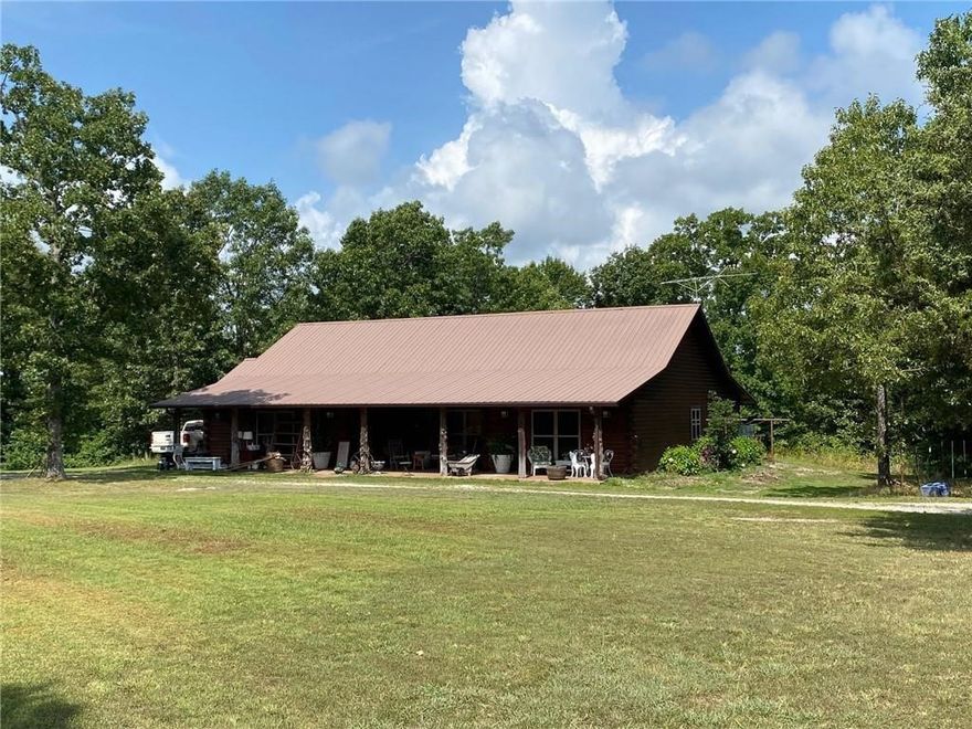 Beautiful custom log home built 2005 features ceramic tile, wood burning stove with creek rock hearth, central HVAC, vaulted living room ceiling, cover front and back porches running entire length of home, 2 car garage and jacuzzi tub in master bathroom. House sits on beautiful development acreage located in the heart of the Ozarks' Boston Mountains. South boundary adjacent to old Dogpatch and Johnny Morris' planned Marble Falls Nature Village in Newton County. Acreage plotted for development with partially completed new graveled interior roads and other old roads throughout. Perfect for development with older roadbeds established along benches. Nice flat pasturelands 10% and sloped timberland 90% with 1/2 mile frontage on Arkansas' Scenic Highway 7. Great hunting! House rental income 16,800/yr. Can also be bought as development acreage, see MLS 1311651.