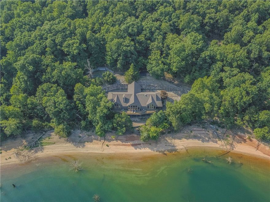 Magnificent lakefront custom home ideally situated on 10.01 acres on Beaver Lake, offering expansive lake views from almost every room.  Interior has tasteful mix of modern amenities and rustic charm creating a warm environment for every season.  Open floor plan, gourmet kitchen, plantation shutters, hand carved beams and much more! Expansive decks ideal for entertaining or just enjoying lake living. Easy walk to the water and to your 3 slip boat dock with lift and swim deck. Tri-toon boat to convey.