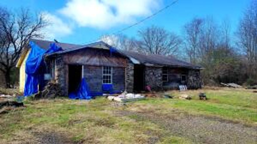* 10 acres along Kneeland Creek* House had a fire being sold as is* Slab Foundation*City water and sewer on property* Part of land in flood plain, due to being located on a creek. House sits up on higher ground.