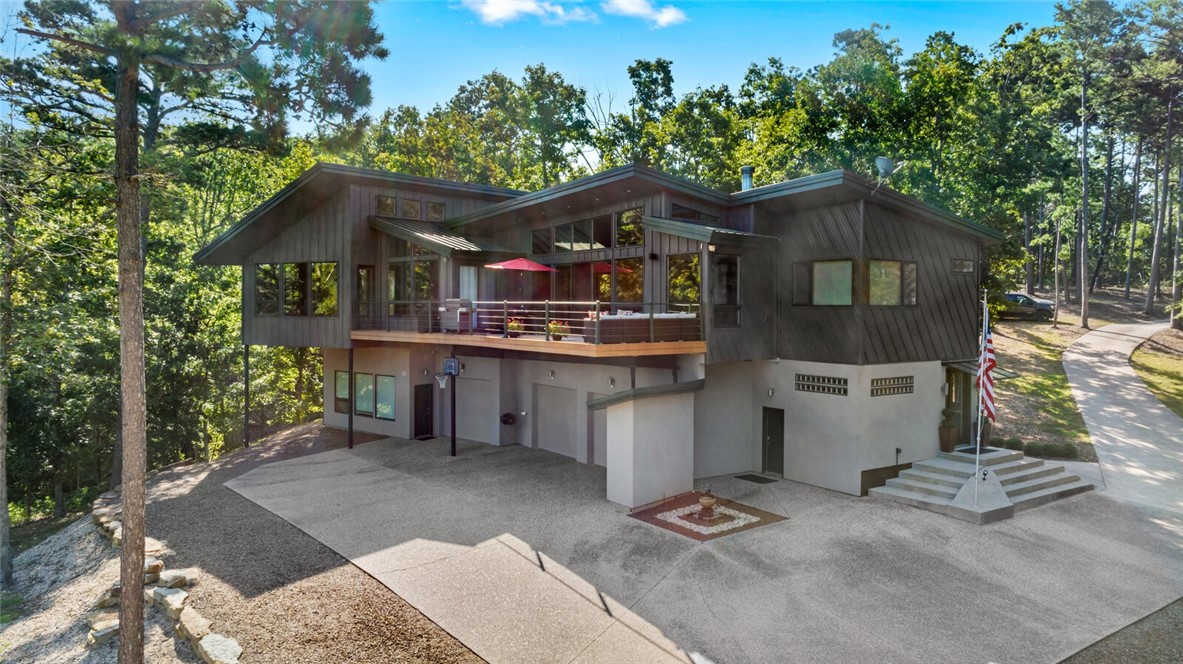Nestled in a secluded wooded setting on Beaver Lake, this contemporary lakefront home offers an
exceptional blend of luxury, nature & modern living. A separate apartment on the lower level adds
flexibility for short-term rentals, guests or a private office. Accessible by elevator, the main level features expansive windows with wooded/lake views, vaulted ceilings, fireplace & tigerwood floors. The gourmet kitchen is equipped with custom cabinets, commercial vented gas range & double ovens. Two ensuite bedrooms are also found on this level. The lower level also includes extra storage rooms & a 3-car garage with a heated workshop. Outdoor living features include a deck with gas grill hookups, paved path leading to the lake & an enchanting trail that takes you to a cold spring waterfall on the property. Also: radiant heating, solar panels, a whole house regenerator and more. Ask for the full List of Features and the option to purchase a boat & lift that will come with a slip transfer at Lost Bridge Marina.