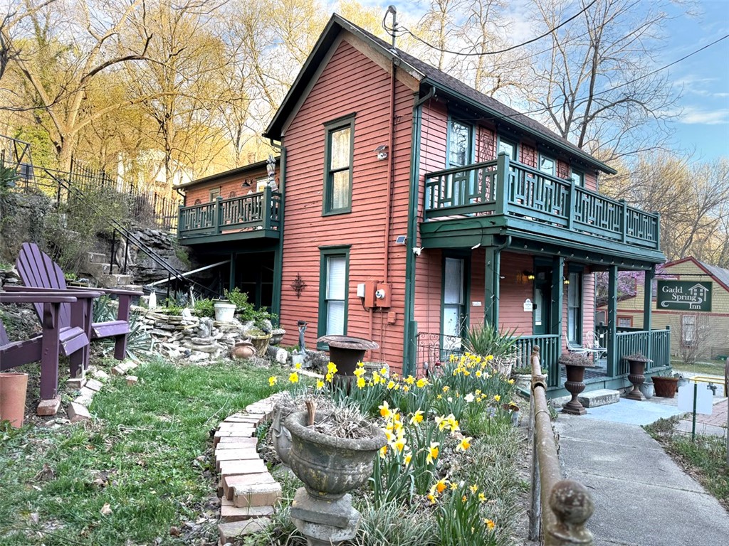 Gadd Spring Inn is a step back in time and embraces the beauty of the meticulously restored 1880's Gadd House. This enchanting property boasts a live spring with grotto creating a serene and unique feature that enhances the beauty of the home. There are three distinctive suites, each designed with its own character. Gorgeous restored flooring, copper ceiling tiles, and exposed original walls showcase the craftsmanship of the era while blending seamlessly with modern comforts. Walk-in showers in each suite offer contemporary amenities and the stained glass windows add an artistic touch. The spacious kitchen with butcher block countertops is ideal for preparing meals for family or guests. Multiple outdoor areas and alcoves surround the home, offering quiet spaces to unwind or entertain while enjoying the scenic surroundings. Era-appropriate furnishings provide a cozy, vintage feel, and most of the furniture, along with all linens, convey with the property, making it a fully turn-key inn, shop or private home.
